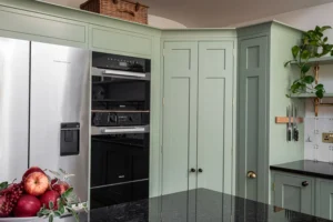 Tall corner larder in Little Greene Boringdon Green between the ovens and sink run at Grantchester Revival