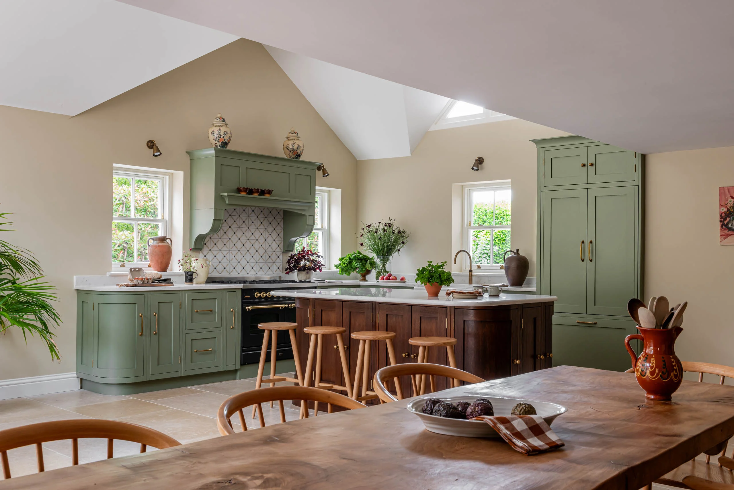 Sage green Shaker kitchen at Innisfree House, Little Greene Sage Green cabinetry with a dark stained oak island and a long dining table